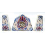 CERANORD; a French Art Deco ceramic clock garniture with stylised red and blue moulded and starburst