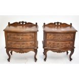 A pair of French style carved bedside chests of two drawers raised on cabriole supports (2).