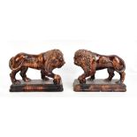 A pair of early 19th century Derbyshire treacle glazed models of lions standing four square with