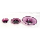 WHITEFRIARS; an amethyst tinted bowl, diameter 30.5cm, and two further smaller pieces of amethyst