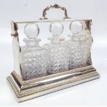 A Betjemann's Patent silver plated three division tantalus with gadrooned detail housing three clear