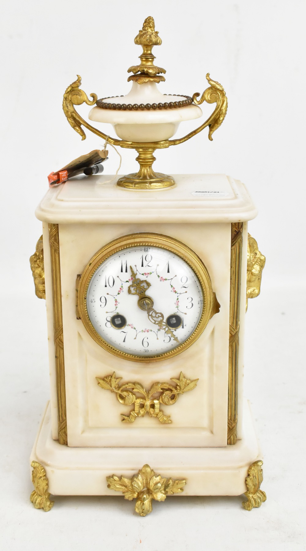 A 19th century alabaster mantel clock with gilt metal mounts and urn finial, the circular painted