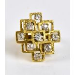An 18ct yellow gold and diamond set ring of abstract stepped design, with nine round brilliant cut
