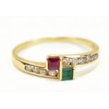 A yellow metal crossover ring set with green, red and white coloured stone, stamped 750 to interior,