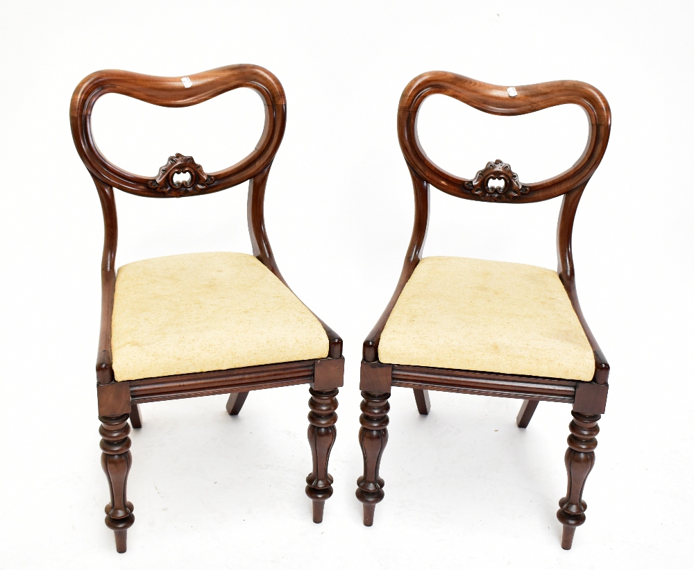 A set of six Victorian balloon back dining chairs, raised on column supports.Additional