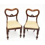 A set of six Victorian balloon back dining chairs, raised on column supports.Additional