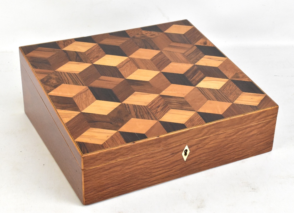 An early 19th century cube parquetry inlaid writing slope, the interior set with inkwells, a leather