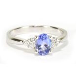 An 18ct white gold tanzanite and diamond ring with central oval tanzanite weighing approx 0.75cts,