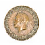 An unusual bronze plaque modelled as the obverse of a George V penny, with 'milled' edge, the