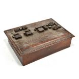An unusual early 20th century carved lidded box, the lid decorated as a series of dwellings beside a