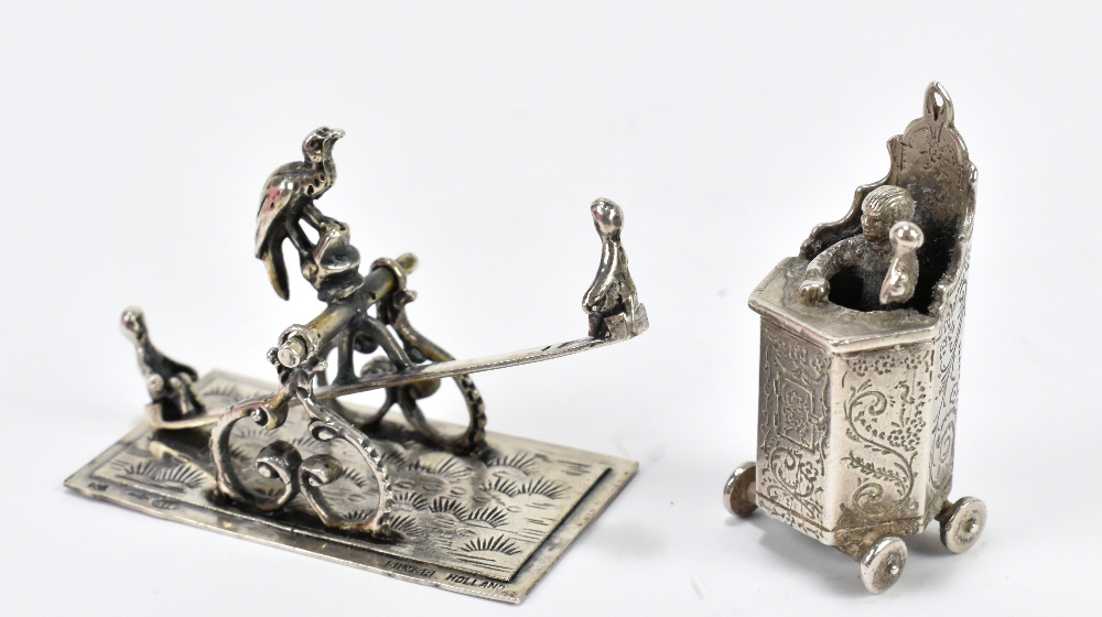 Two Dutch silver novelty miniatures comprising a seesaw and a gentleman upon a rostrum, possibly