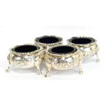 A set of four Victorian hallmarked silver circular salts with embossed floral swags raised on