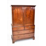 A George III mahogany linen press, the top section with two panelled doors enclosing two drawers