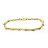 An 18ct yellow gold diamond and emerald bracelet set with fifteen emeralds totalling 1.5cts, and 105