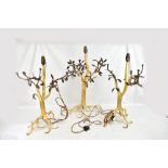 An unusual suite of three gilt and wrought iron lamp bases in the form of rooting trees with