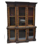 A Victorian carved oak breakfront bookcase, the upper and lower sections each with three glazed