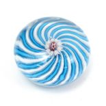 CLICHY; a circular glass paperweight with central flower cane and blue and white scrolled effect,