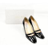 JIMMY CHOO; a pair of black buckled Mary Jane pumps made in Italy from patent leather with an 8cm