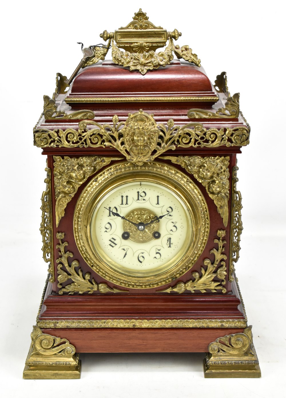 A large late 19th/early 20th century mantel clock with gilt metal foliate and cherubic mounts, the