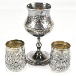 A pair of white metal beakers with repoussé foliate detail, both stamped 'silver' to bases, height