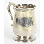 A George II hallmarked silver baluster mug, with engraved cross inscribed 'Ire In Adversa', on