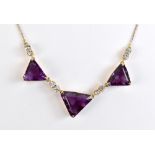 A yellow metal amethyst and white sapphire necklace, three large triangle cut amethysts divided by