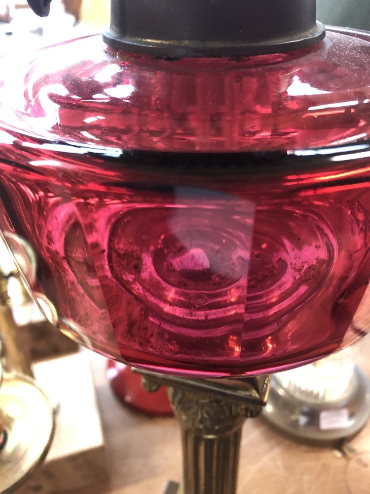 A Victorian brass oil lamp with faceted cranberry glass reservoir and milk glass shade, height 72cm. - Image 5 of 6