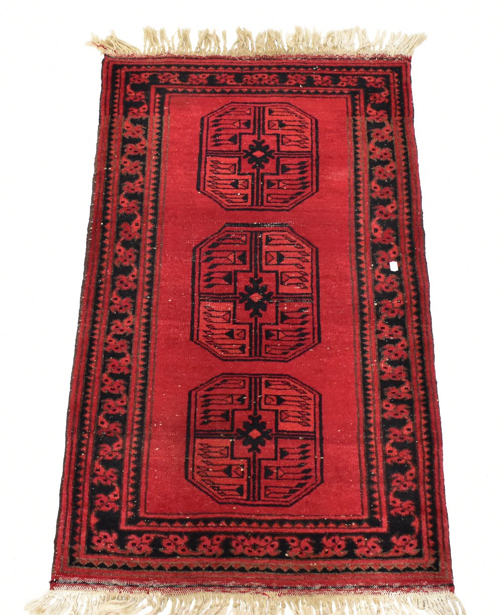 An Eastern rug with stylised decoration on a predominantly red ground.Additional Information131cm