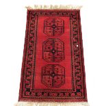 An Eastern rug with stylised decoration on a predominantly red ground.Additional Information131cm