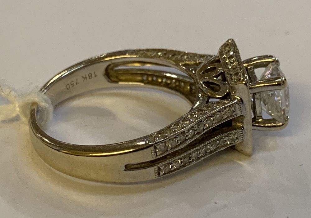 An 18ct white gold and diamond ring, the raised central princess cut stone within a border of twenty - Image 2 of 4