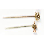 A yellow metal stick pin with knot terminal and a further stick pin with a hunting horn, af.