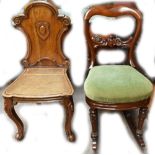 A mahogany framed upholstered rocking chair and a carved oak hall chair (2).