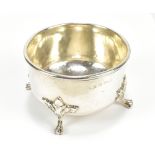 ALBERT EDWARD JONES: a George V hallmarked silver circular bowl, with hammered finish, on four paw