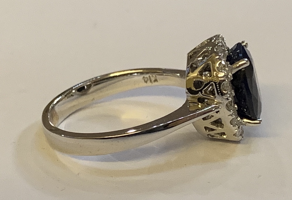 A white metal diamond and sapphire cluster ring, the modified brilliant cut sapphire weighing approx - Image 3 of 5