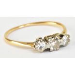 A yellow metal and diamond three stone ring, the central stone weighing approx 0.25ct, size N,