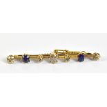An Edwardian yellow metal bar brooch set with five diamonds and two sapphires, unmarked, length 5.