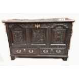 An 18th century oak blanket box with internal candle box, later carved front, two drawers and raised