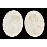 An opposing pair of oval reconstituted marble plaques, relief moulded with busts of classical-