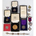 A group of medals and medallions, also a Masonic jewel, bracelet, horse shoe, enamel decorated