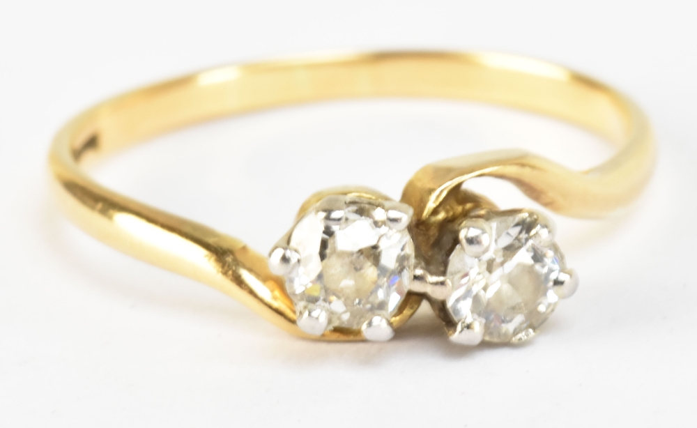 A yellow metal and diamond two stone crossover ring, each stone weighing approx 0.25ct, marked to