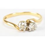 A yellow metal and diamond two stone crossover ring, each stone weighing approx 0.25ct, marked to