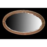 An Arts and Crafts copper framed oval mirror with hammered finish and bevelled glass, 80 x 47cm.