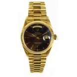 ROLEX; a gentleman's Oyster Perpetual Daydate 18ct gold wristwatch, the black dial set with baton