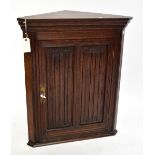 A reproduction oak flat fronted Priory-style corner cupboard.