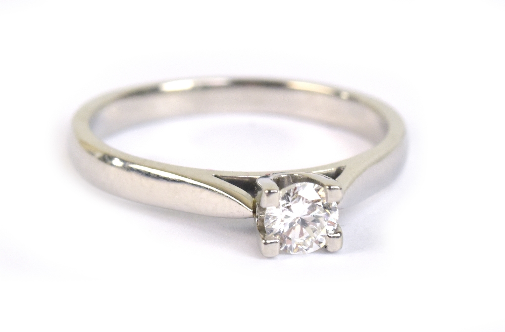 A platinum and diamond solitaire ring, the brilliant cut stone weighing approx 0.20cts, in four claw