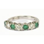 An 18ct white gold emerald and diamond seven stone ring, the three diamonds totalling approx 0.60ct,