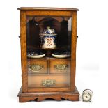 An early 20th century oak smoker's cabinet, with glazed door, height 43cm.