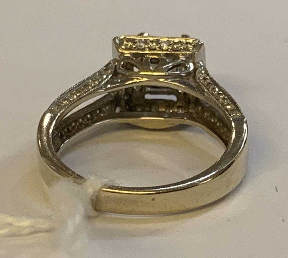 An 18ct white gold and diamond ring, the raised central princess cut stone within a border of twenty - Image 3 of 4