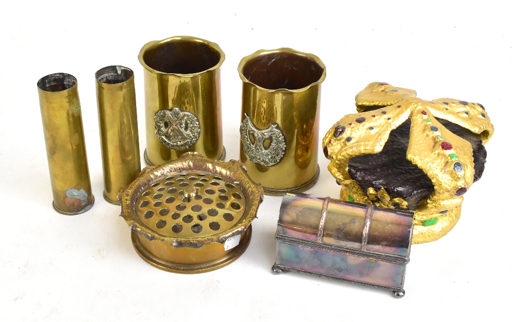 A small group of metal ware including trench art vases with applied cap badges and ash tray, a