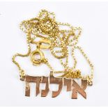 A yellow metal necklace pendant of Hebrew lettering, suspended on a 9ct yellow gold chain, approx
